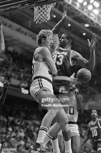 Larry Bird passes ball off behind Pacers' Clark Kellogg in 1st quarter action at Boston Garden.