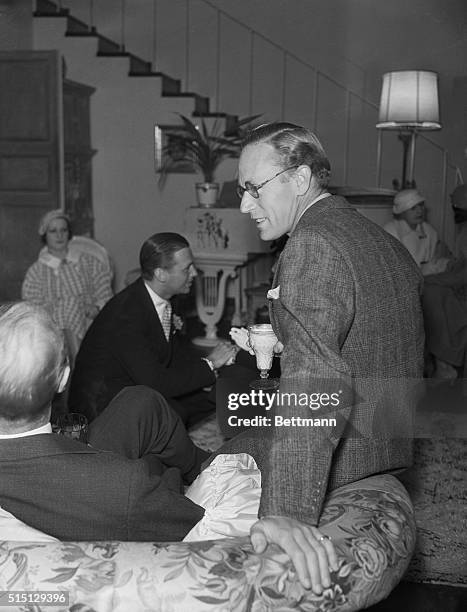 Stars at Easter Tea...Leslie Howard, popular movie actor, chats with a friend during the Easter Tea given annually by Lilyan Tashman and Edmund Lowe...