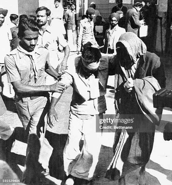 Two people help a victim of the Bhopal chemical leak evacuate the disaster site, in Bhopal, India. The Bhopal Disaster was one of the world's worst...