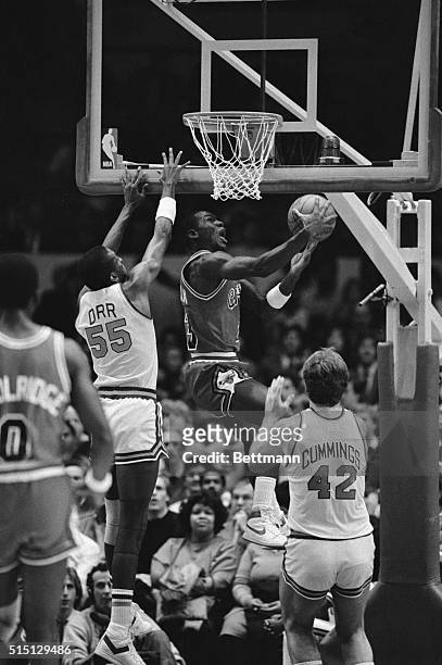 Chicago Bulls' star Michael Jordan leaps above New York Knickerbockers' Louis Orr and Pat Cummings as he goes up to sink an overhead layup during the...