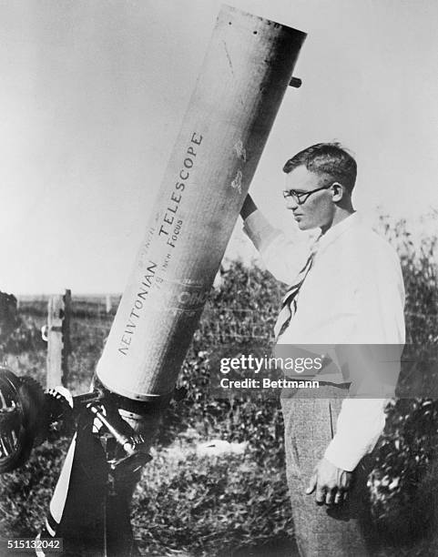 Clyde Tombaugh, a 24 year old student and the discoverer of the planet Pluto, looks over a Newtonian reflecting telescope he built in 1928.