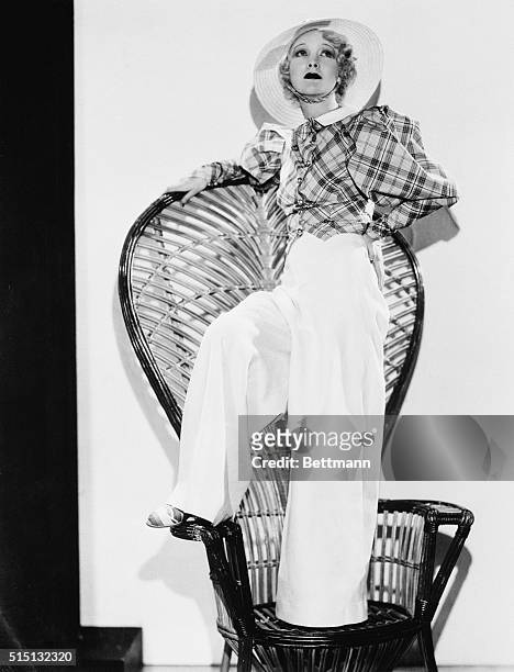Sand ensemble...White linen slacks combined with a chic puff-sleeve jacket of plaid makes this becoming beach ensemble for Helen Twelvetrees,...