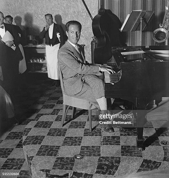 Miami Beach, FL- George Gershwin, foremost, present-day, music composer, is seen here at the piano, at the Deauville pool where he is vacationing.
