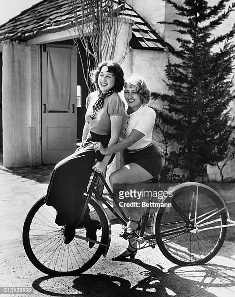 Not a bicycle built for two but Joan Blondell, one of Hollywood's best known stars, takes her sister, Gloria, for a ride on the handlebars of her...