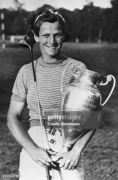 And now Mildred Babe Didrikson has entered new fields of sport and conquered them in short order. Here she is proudly clutching the trophy she won in...