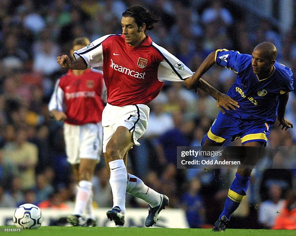 Arsenal's  French player Robert Pires (L) is chase