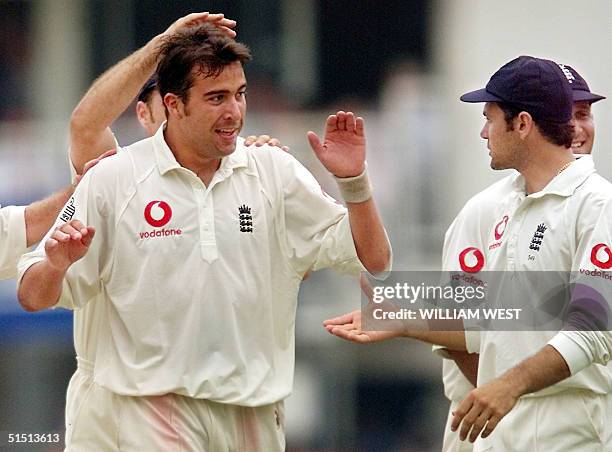 New England fast bowler James Ormond is congratulated by teammate Mark Ramprakash after taking his first test wicket, the wicket of Australian...