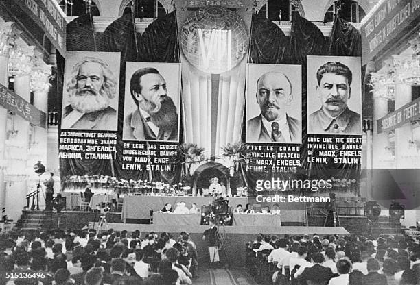 Communists gather for an important meeting in the House of Trade Unions in Moscow, with multilingual proclamations and banners of "fathers" of the...