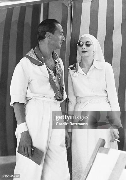 Italian actor Nerio Bernardi with a fashionably-dresssed woman on the Lido in Venice, Italy, 19th August 1935.