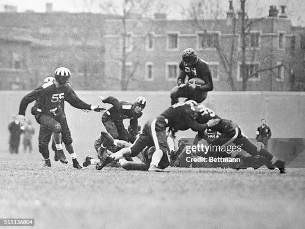 Climbing out of Big Ten Cellar. Jay Berwanger, Maroon left halfback, caught by the camera, high in the air as he returned the opening kickoff to the...