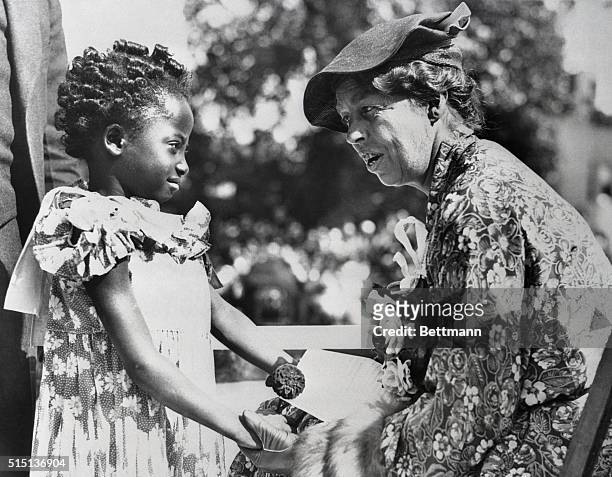 First Lady at Detroit's Slum Clearance. Mrs. Anna Eleanor-Roosevelt, wife of the Chief Executive, talks to five-year-old Geraldine Walker at the...