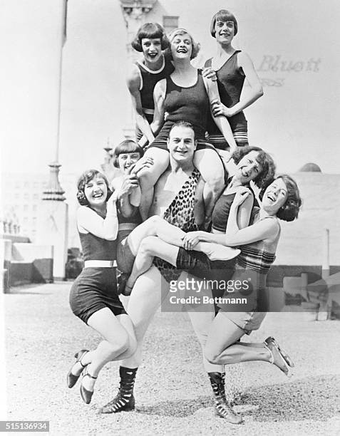 Wonderful Handler of the Ladies: Los Angeles, California: Photo shows Bonomo, world's strongest human, as he bears seven bathing girls between scenes...