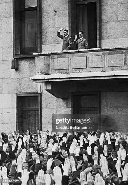 Chancellor Adolf Hitler, Propaganda Minister Joseph Goebbels at his side, acknowledges cheers of well-wishers who gathered in front of the...