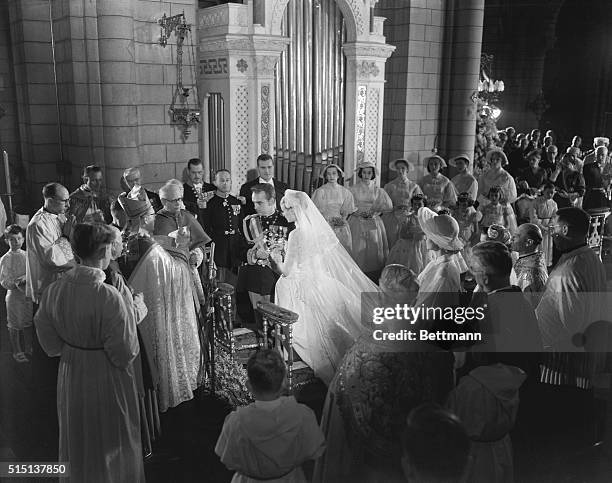 Her serene highness, Princess Grace Patricia, assists Prince Rainier III as he has some difficulty in putting the ring on her finger during colorful...