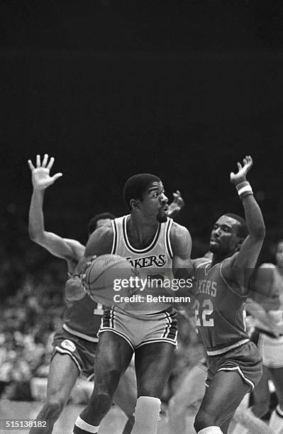 Los Angeles Lakers Earvin "Magic" Johnson looks for a receiver as he is covered by two Philadelphia 76ers early in game three of the NBA Championship...