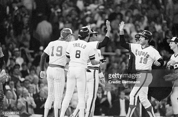 Fred Lynn, of the California Angels, has a big grin 7/6 as he is greeted by American League teammates after hitting grand-slam homer, the first in...