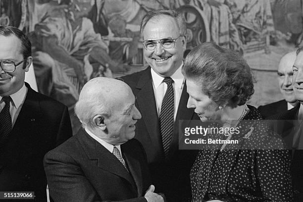 Copenhagen, Denmark: Prime Minister Amintore Fanfani chats with British prime minister Margaret Thatcher as West German chancellor Helmut Kohl smiles...