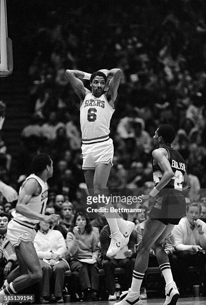 Sixers' Julius Erving takes to the air to pass a ball off in the first quarter in Philadelphia 2/16 over Denver Nuggets' Alex English. Sixers won...