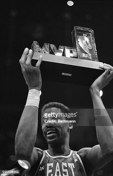 East All Star Julius Erving holds up the Most Valuable Player trophy after the East-West NBA All Star game at the forum here 2/13 that was won by the...