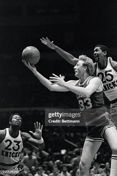 Larry Bird keeps ball from the reach of the Knicks' Bill Cartwright during their contest at Madison Square Garden, 3/5. The New Yorkers beat Boston,...