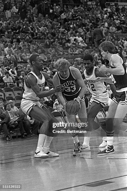 Boston forward Larry Bird drives for the hoop as Indiana forward George Johnson and Indiana Guard Butch Carter attempt to stop him during first...