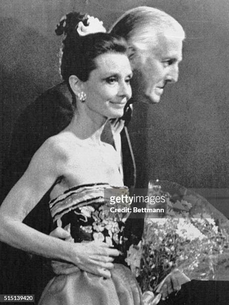 Paris fashion designer Hubert De Givenchy is shown with American actress Audrey Hepburn as each responds to applauding audience at final stage of the...