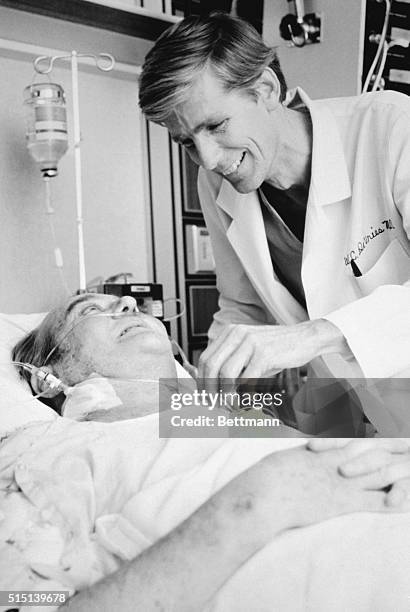 Artificial heart recipient Barney Clark smiles up at Dr. William DeVries, leader of the medical team that performed the surgery, on December 3rd, a...