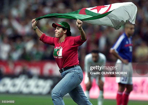 A supporter runs on the field with an Algerian flag during the friendly soccer match France vs Algeria at the Stade de France in Saint-Denis 06...