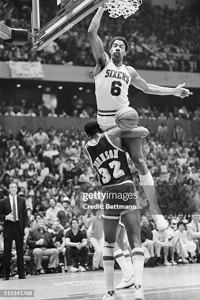 Sixers' Julius Erving is held up by Laker's Magic Johnson after scoring a dunk in the fourth quarter in Philadelphia. The Sixers won 113-107.