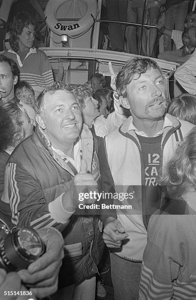Alan Bond, head of the Australian II syndicate gives the thumbs up sign as he and skipper John Bertrand are surrounded by fans following their...