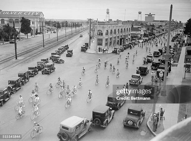 Pedallers A-Plenty. Los Angeles, California: Auto traffic moves to one side as 300 girl bicycle riders swoop down a Los Angeles street during their...