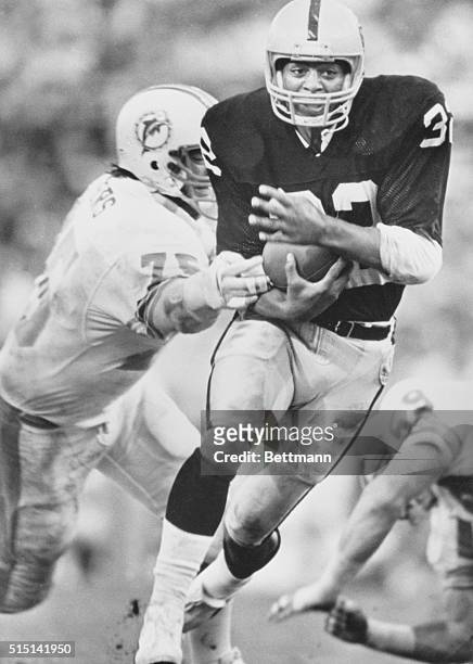 Miami: Marcus Allen of Los Angeles eludes the grasp of Doug Betters of Miami in first half action 12/1. Allen scored three touchdowns in the game...