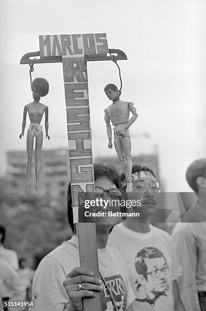Manila: Barbie dolls representing President Ferdinand Marcos and First Lady Mrs. Imelda Marcos hang from a T-square converted into protest placard by...
