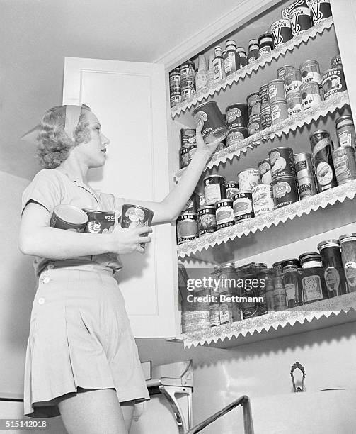 Leila Hyams, movie star, stocks up on canned goods in the kitchen of her Malibu beach house.