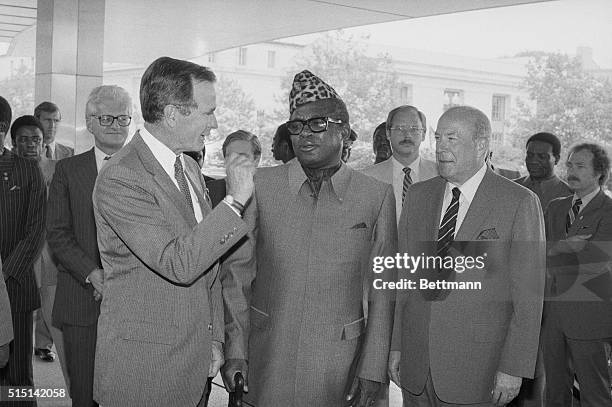 Washington, D.C.: President of Zaire, Mobutu Sese Seko, , is greeted by Vice President George Bush and Secretary of State George Shultz at the State...