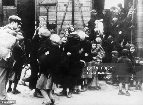 Mother with their children step carefully out of the freight wagons that brought them to Oswiecim, Poland. They were tired after several days...