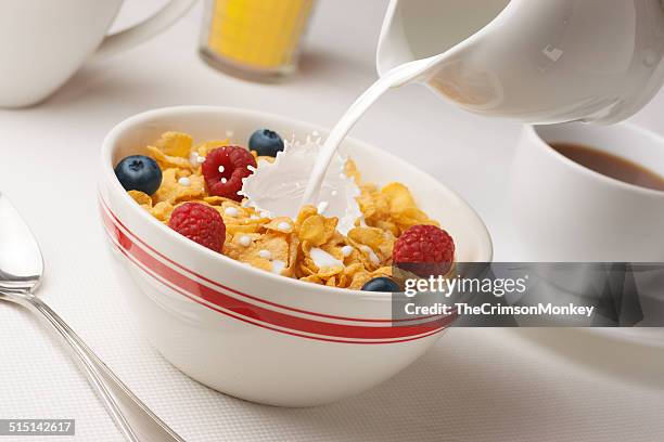 milk pouring on cereal - cornflakes stock pictures, royalty-free photos & images