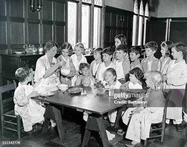 Children look on with interest as Mrs. Franklin D. Roosevelt pours milk for some of them during her visit at the Progressive School of the Vassar...