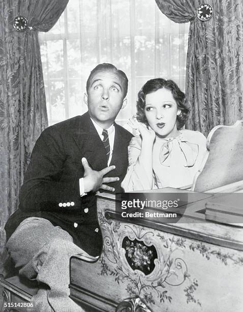 His Best Friend and Severest Critic. Mrs. Bing Crosby listens with approval as Mr. Bing croons a few tunes in preparation for that approaching...