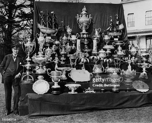 Photo shows Sir Thomas Lipton, noted boat racing enthusiast, with the largest and most valuable collection of gold and silver sporting trophies ever...