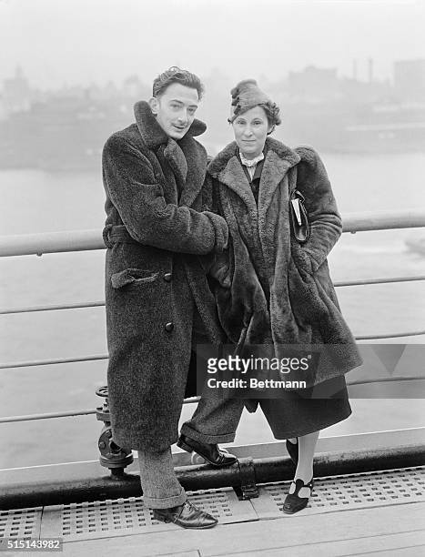 Salvador Dali, the well known Spanish Surrealist painter, and Mrs. Gala Dali, are snapped here aboard the S. S. Normandie upon arrival in New York...