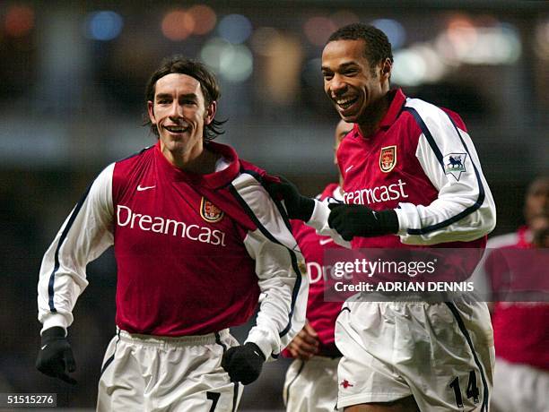 Arsenal's French players Robert Pires and Thierry Henry celebrate Pires' equalising goal in the second half during the Premier League match at...