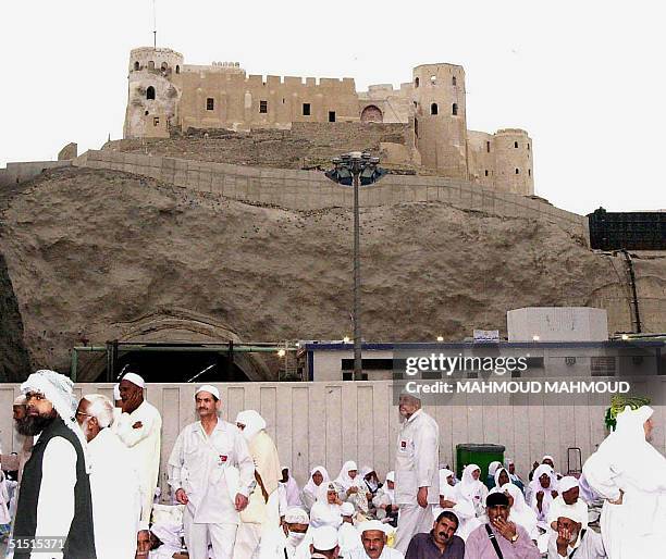 Picture dates March 2001, shows Muslim pilgrims sitting under an Ottoman fortress overlooking the Grand Mosque in Islam's holiest city of Mecca....