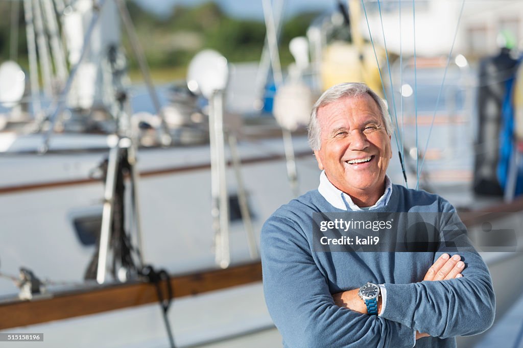 Glücklich leitender Mann lächelnd auf einem Boot im Hafen