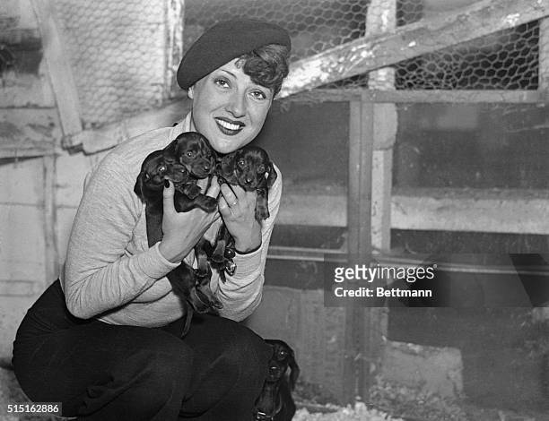 Mrs. Robert Mizzy, formerly Louise Hovick, and known on the stage as Gypsy Rose Lee, with her pet dogs, pictured at her home in Highland Mills, N.Y.,...