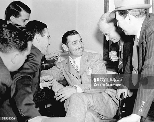 Clark Gable and newspaper reporters are shown in a mutually enjoyable interview during recess in Los Angeles Court, April 23 at the trial of...