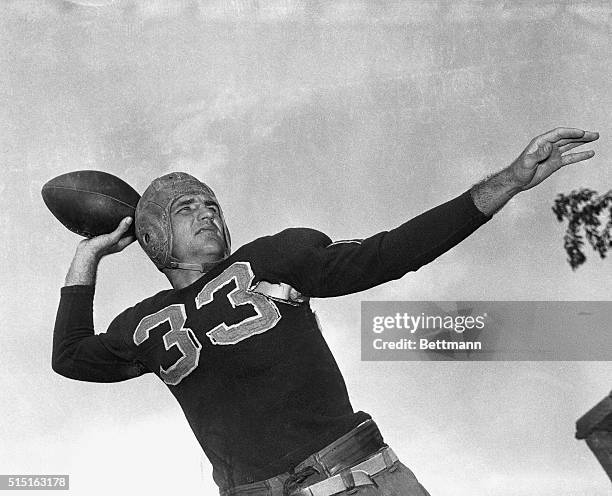 Washington Redskins' famed passer, Sammy Baugh preparing tp pass football.
