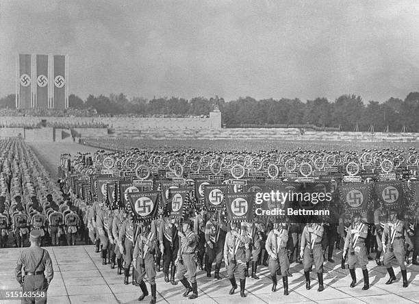 The arena of the stadium packed solidly with Storm Troopers and SS Men, carrying swastika banners, as 120,000 persons at the tenth Nazi party...