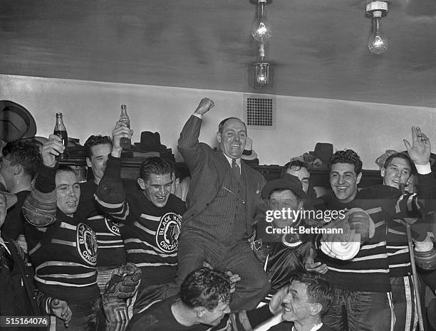 The Chicago Black Hawks are shown as they carried Manager Bill Stewart on their shoulders in the parade to the dressing room after they had defeated...