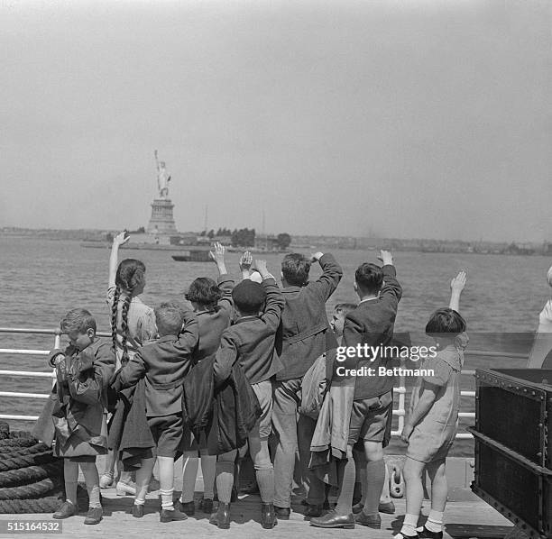 Group of young Austrian immigrants wave to the Statue of Liberty upon their arrival in America aboard the S.S. Harding. The fifty Jewish children,...